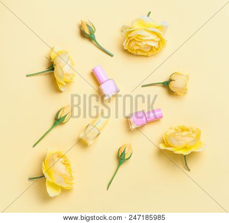 Nail Polish Bottle And Yellow Roses On Yellow Background. Trendy Manicure Concept, Pure Colors.