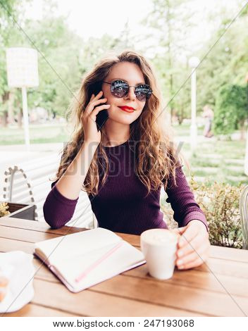 Beautifl Attractive Young Blonde Woman With Curly Hair Drinking Cappuccino And Talking On Telephone 