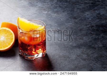 Negroni cocktail on dark stone table. With space for your text