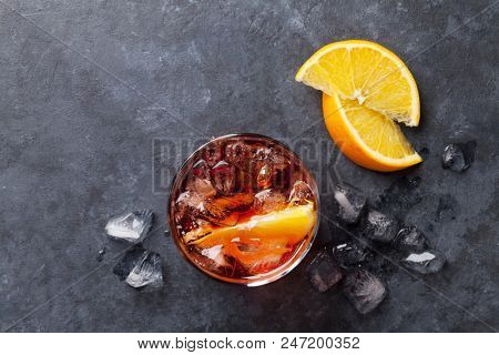 Negroni cocktail on dark stone table. Top view with space for your text