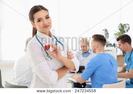 Female Doctor Holding Small Heart In Clinic. Cardiology Center
