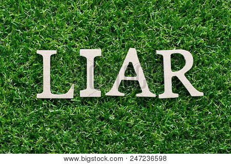 Wood Alphabet In Word Liar On Artificial Green Grass Background