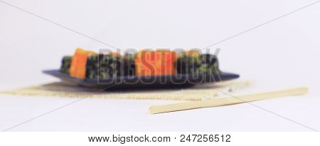 Different Types Of Maki Sushi On A Black Plate.isolated On White Background