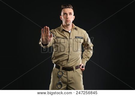 Male Security Guard With Police Baton On Dark Background