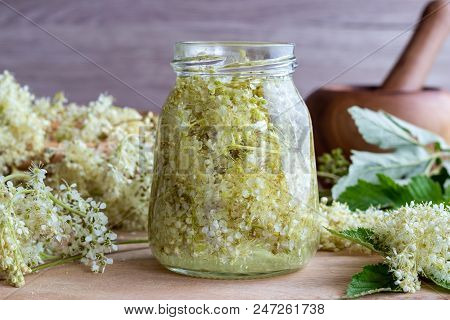 A Jar Filled With Meadowsweet Blossoms And Alcohol, To Prepare Homemade Tincture