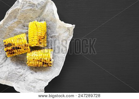 Grilled Corn On The Cob Ove Black Background, Top View. Summer Food. From Above, Flat Lay. Copy Spac