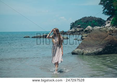 Handsome Girl On The Beach Background. Portrait Of A Woman In White Clothes On The Sea