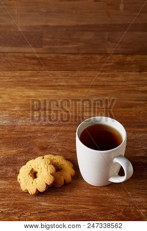 White Porcelain Mug Of Black Tea Or Earl Grey And Pile Of Sweet Cookies On Rustic Wooden Background,