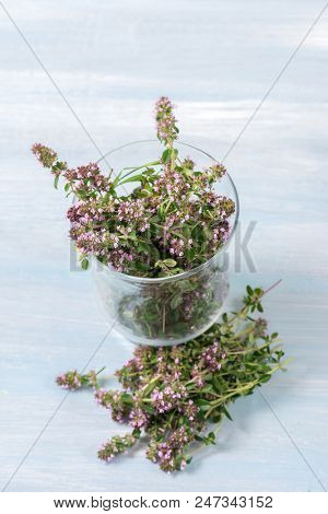 flowering oregano in a glass on a wooden table