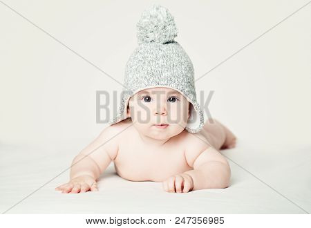 Baby In Knitted Hat Lying On White Blankett, Portrait. Pretty Little Child (3 Months Old)