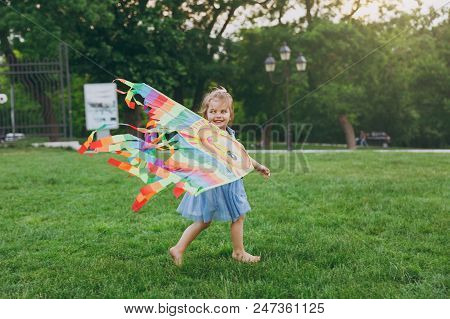 Pretty Little Cute Child Baby Girl In Denim Dress Walking, Play With Colorful Kite And Have Fun In G