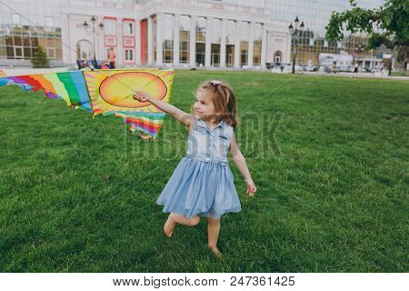 Smiling Little Cute Child Baby Girl In Denim Dress Running, Play With Colorful Kite And Have Fun In 
