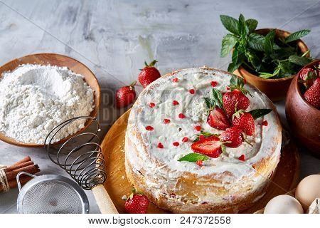 Strawberry Tart Covered With Whipped Sour Cream Surrounded By Organic Ingredients Over White Backgro