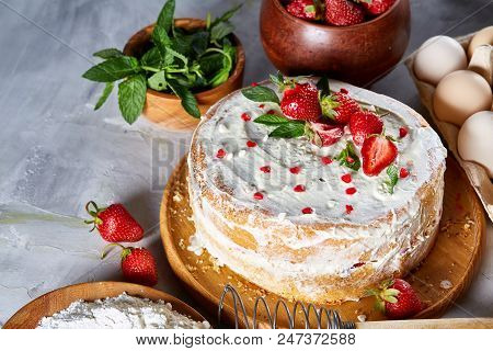 Strawberry Tart Covered With Whipped Sour Cream Surrounded By Organic Ingredients Over White Backgro