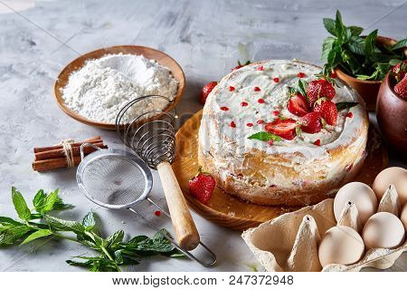 Strawberry Tart Covered With Whipped Sour Cream Surrounded By Organic Ingredients Over White Backgro