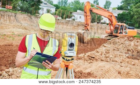 surveyor worker with theodolite at construction site