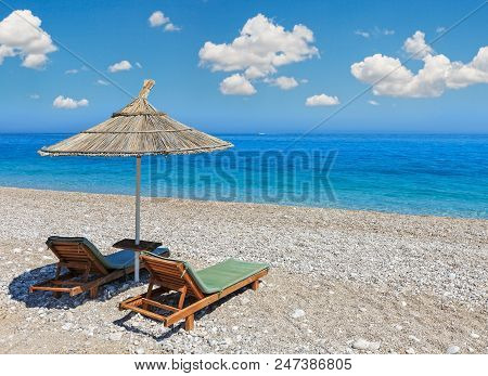 Summer Morning Sandy Beach With Sunbeds And Strawy Sunshade (albania). Deep Blue Sky With Some Cumul