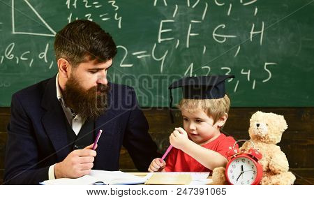 Hometask Concept. Father Checking Hometask, Helps To Boy, Son. Enthusiastic Kid Studying With Teache