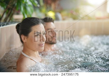Couple relaxing in spa resort hot pool