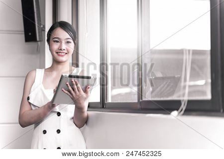 Modern business woman stainding with tablet in the office, copy space.
