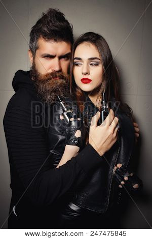 Brutal Bearded Man And Young Beautiful Woman Smoking Electronic Cigarette In Vape Bar. Bad Habits, P