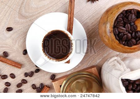 boisson chaude sucrée : café arabe en petite tasse blanche avec mortier et pilon, sac plein haricots, co noir