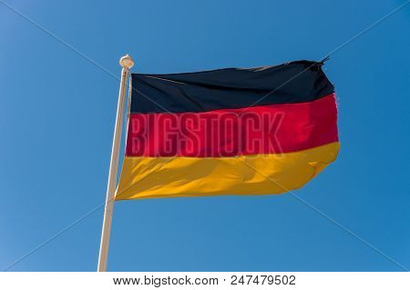 German Flag Waving Against Blue Sky In Wimereux, France.