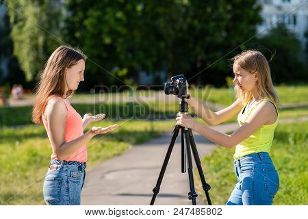 Two Girls Schoolgirl. Summer In Nature. Record Video On The Camera. Conducts A Video Broadcast On Th