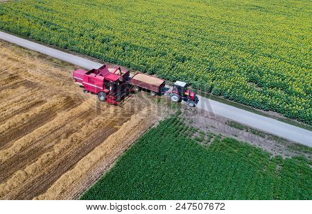 Top View Of Combine Harvester And Tractor In Field