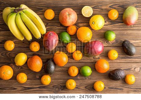 Scattered Assorted Fresh Tropical Fruit On Wood For A Healthy Diet With Bananas Or Plantains, Mango,