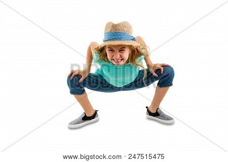 Mischievous Naughty Little Girl Bending Forwards Towards The Camera With An Impish Grin In A Trendy 