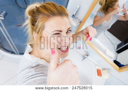 Woman Brushing Cleaning Teeth Closeup. Funny Blonde Girl With Toothbrush In Bathroom Making Thumb Up