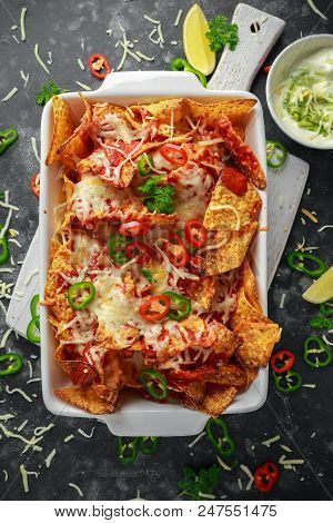 Maxican-style Tortilla Nachos Chips Topped With Tomato Salsa, Sliced Chilies And Melted Cheese Serve
