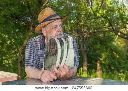 Outdoor Portrait Of Positive Elderly Man Bee-keeper