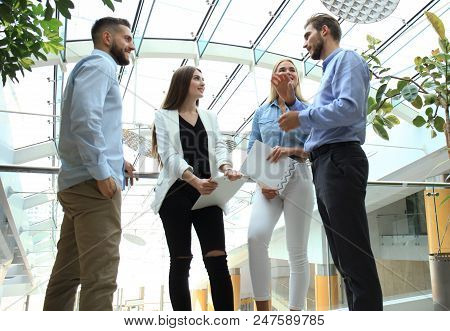 Young Modern Colleagues In Smart Casual Wear Having A Brainstorm Meeting While Standing In The Creat