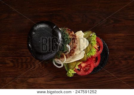 Black Burger On Vintage Wooden Background, Top View, Close-up, Selective Focus. Artistic Layout. Exo