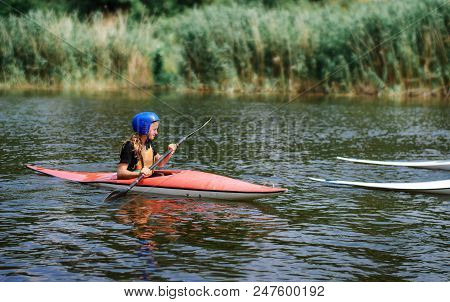 Young Teenager Girl Actively Manages A Sports Kayak Boat On A Beautiful River