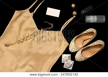 A Set Of Erotic Women's Clothing And Accessories For Sexual Games. Gold Objects On A Black Backgroun