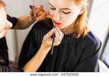 Makeup Artist Applies Red Lipstick On The Beautiful Woman Face.