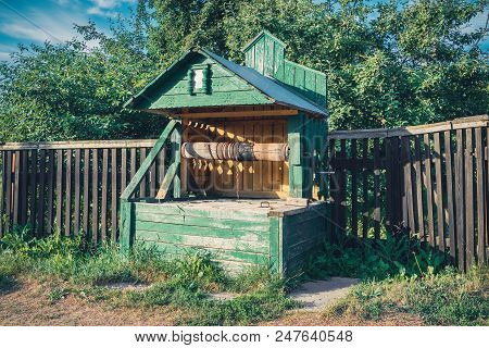 Vintage Wooden Water Well In Village. Retro Styled.