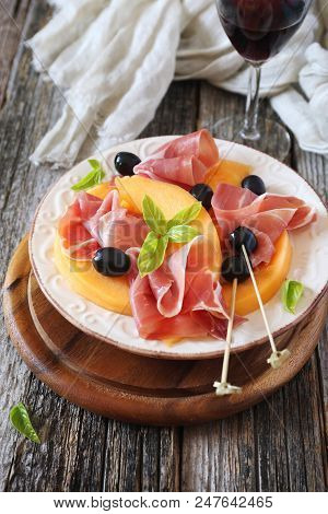 Prosciutto With Melon And Glass Of Red Wine.traditional Italian Appetizer