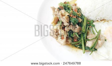 Fried spicy fried seafood with basil leaves and mixed vegetable and fried egg on jasmine rice in whi