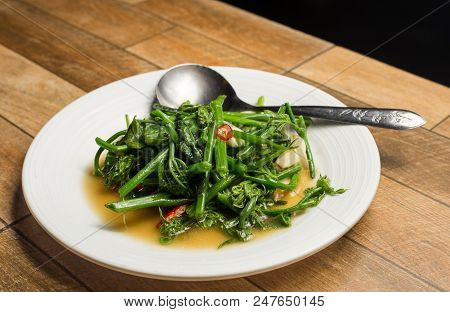 Stir Fried Water Spinach Or Vietnamese Fried Morning Glory, Rau Muong Xao Toi On White Dish On Wood 