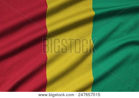 Guinea Flag  Is Depicted On A Sports Cloth Fabric With Many Folds. Sport Team Waving Banner