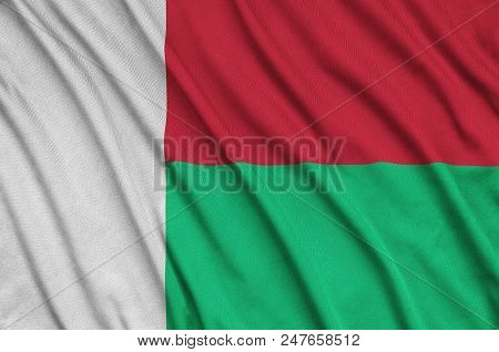 Madagascar Flag  Is Depicted On A Sports Cloth Fabric With Many Folds. Sport Team Waving Banner