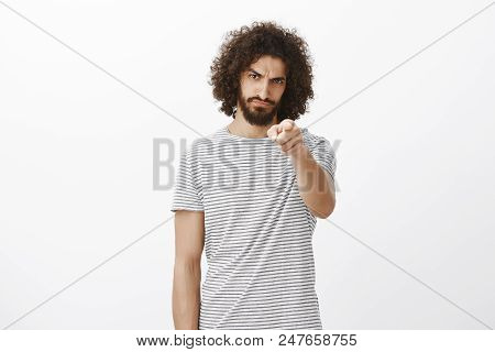 Portrait Of Offended Outraged Handsome Hispanic Guy With Beard And Afro Haircut, Pointing With Blame