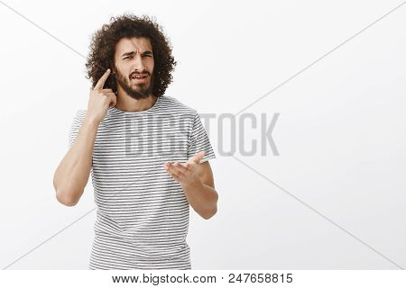 What I Cannot Hear You, What Do You Want. Portrait Of Confused Bothered Handsome Eastern Guy With Af