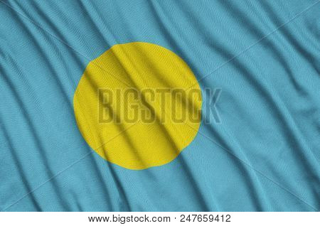 Palau Flag  Is Depicted On A Sports Cloth Fabric With Many Folds. Sport Team Waving Banner