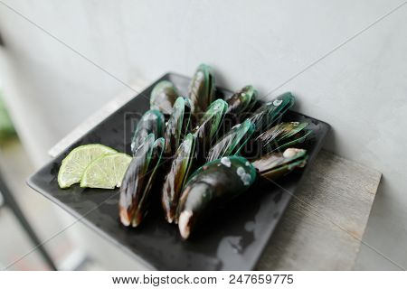 Ousters Near Lmon On Black Plate. Concept Of Seafood.