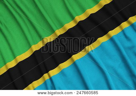 Tanzania Flag  Is Depicted On A Sports Cloth Fabric With Many Folds. Sport Team Waving Banner